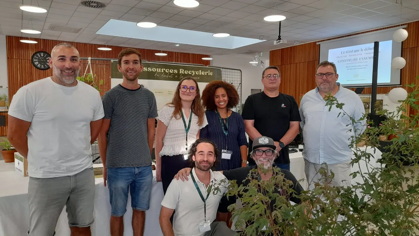 L'équipe de l'association Ressources posant avec les élus présents lors de la journée du 3 octobre, devant le stand de la recyclerie